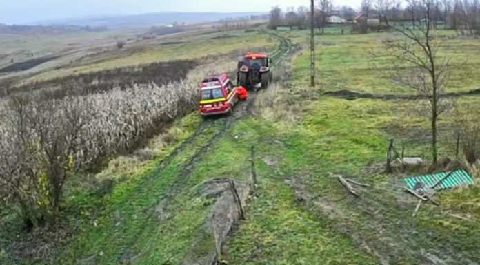 Salvare cu tractorul — ambulanța blocată în noroi, tractată până la pacient